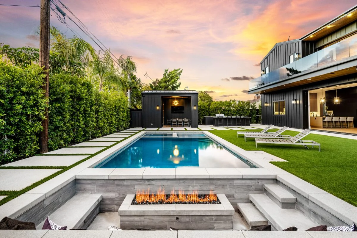 Modern backyard with pool and fire pit at sunset